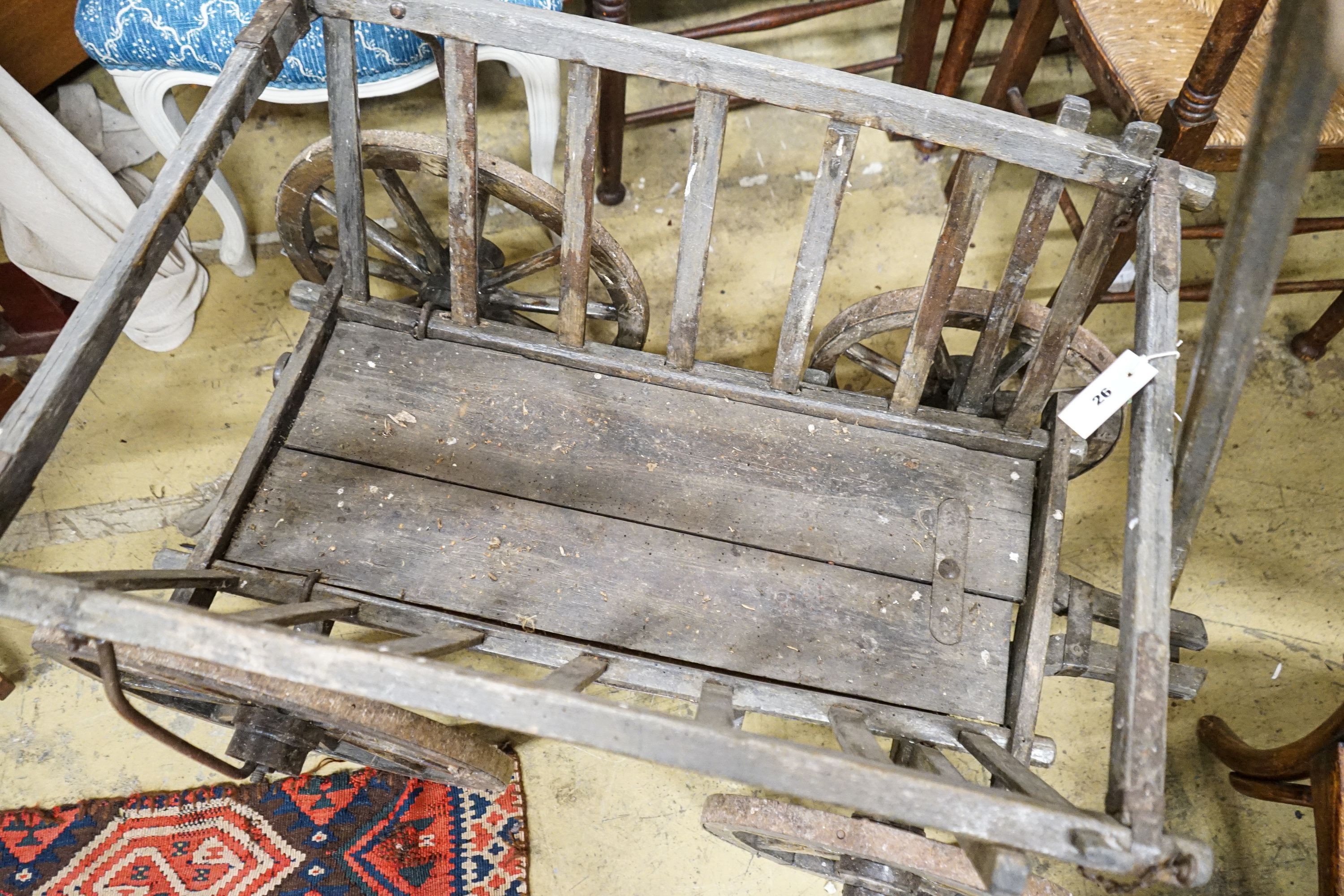 A Victorian oak and beech framed child's cart, with iron bound spoked wheels, length 104cm, depth 58cm, height 60cm